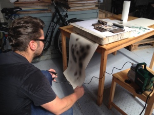 Thomas probiert die Airbrushpistole aus für den Druck in der Lithgrafie